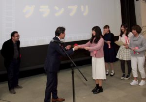 つくッぺ表彰式 写真左から中村義洋監督(特別審査員)、市原健一つくば市長、受賞学生(7名のうち4名が登壇)